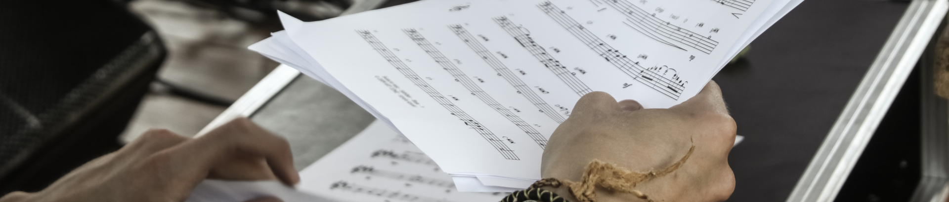 picture of hands holding new sheet music from pexels
